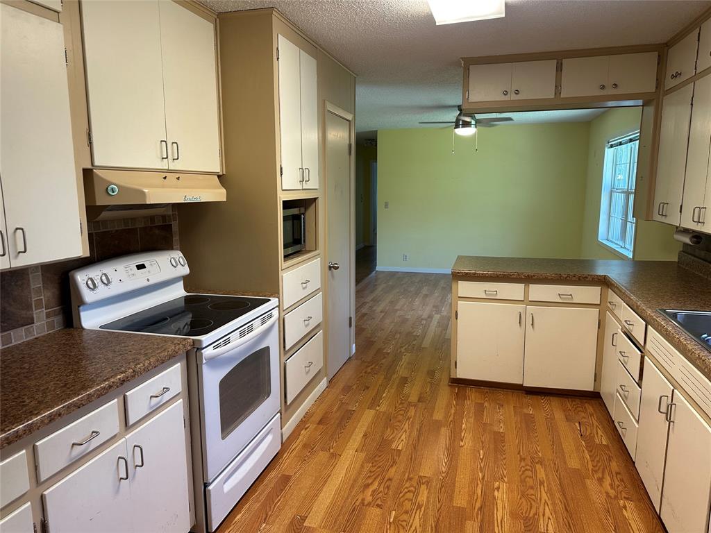 406 South Williams Street Hamilton, TX 76531 - Photo 11 of 35 a kitchen with a stove and a refrigerator