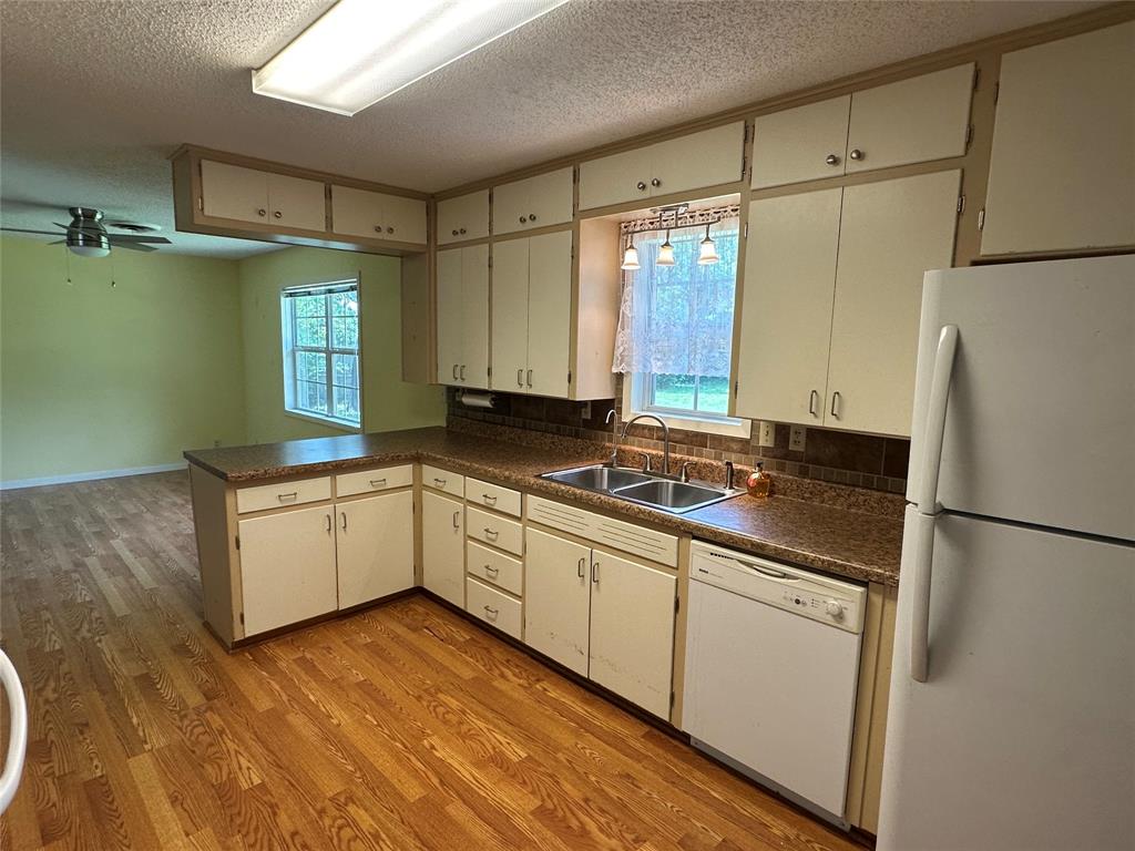 406 South Williams Street Hamilton, TX 76531 - Photo 12 of 35 a kitchen with a refrigerator and a sink
