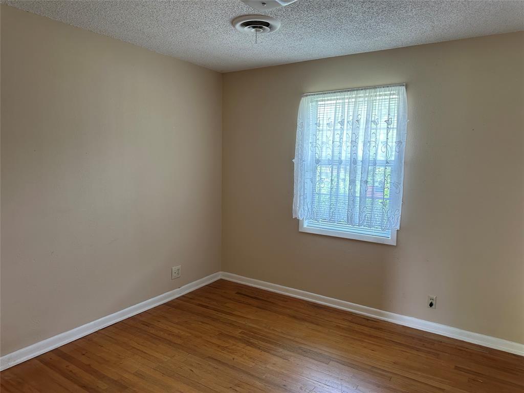 406 South Williams Street Hamilton, TX 76531 - Photo 15 of 35 wooden floor in an empty room with a window
