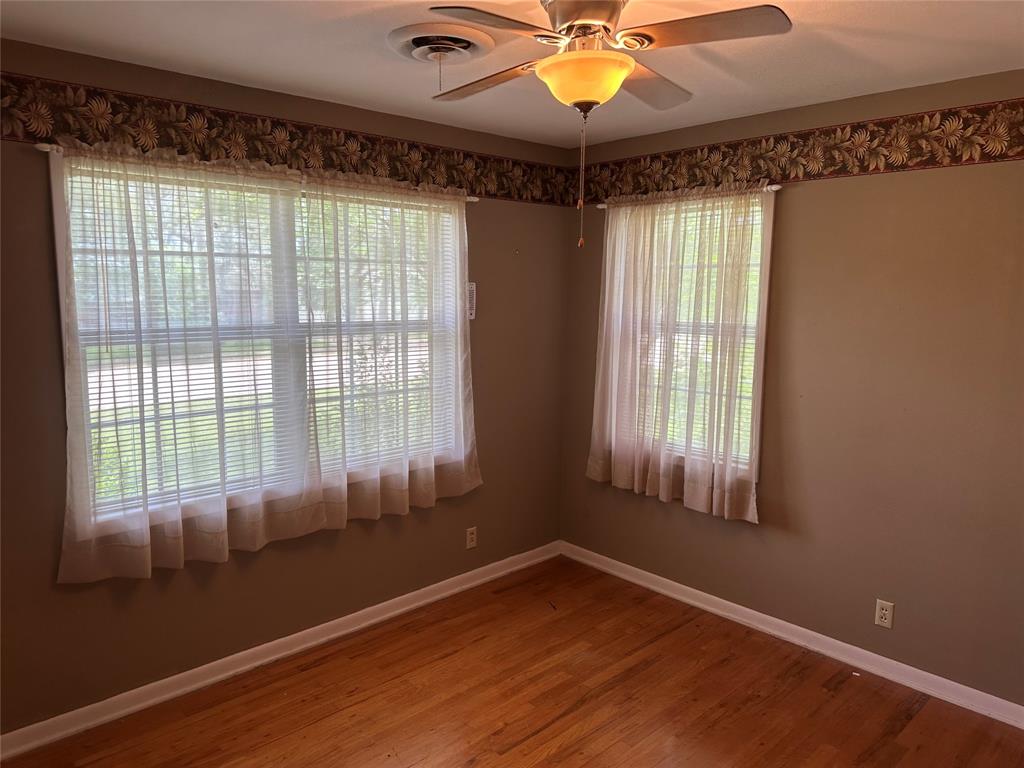 406 South Williams Street Hamilton, TX 76531 - Photo 17 of 35 a view of an empty room with a window and wooden floor