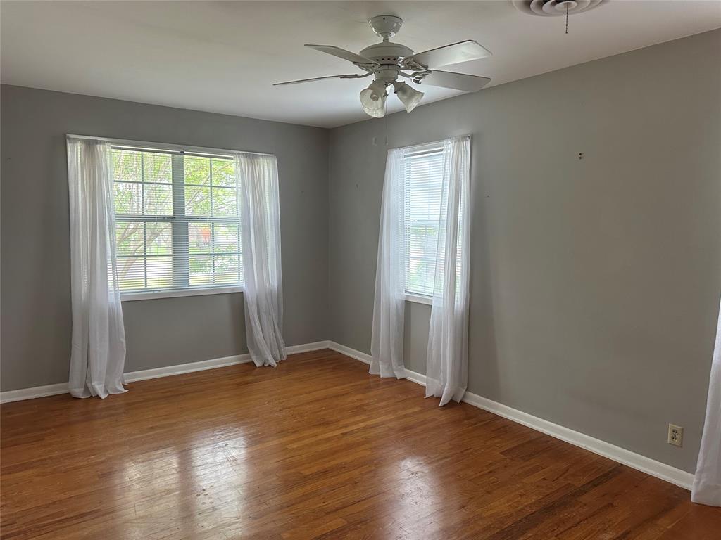 406 South Williams Street Hamilton, TX 76531 - Photo 22 of 35 an empty room with wooden floor and windows
