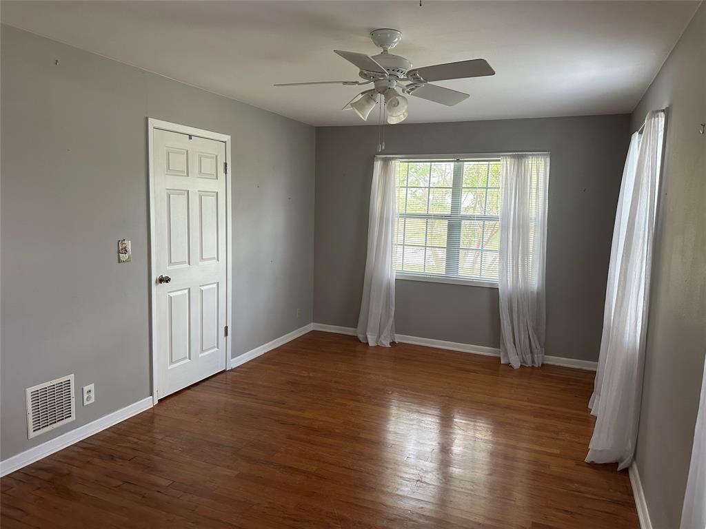 406 South Williams Street Hamilton, TX 76531 - Photo 23 of 35 an empty room with wooden floor and windows