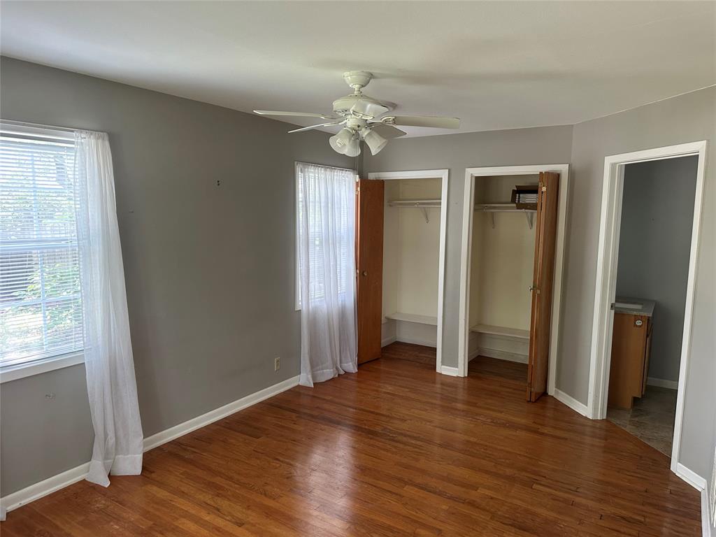 406 South Williams Street Hamilton, TX 76531 - Photo 24 of 35 an empty room with wooden floor fan and windows