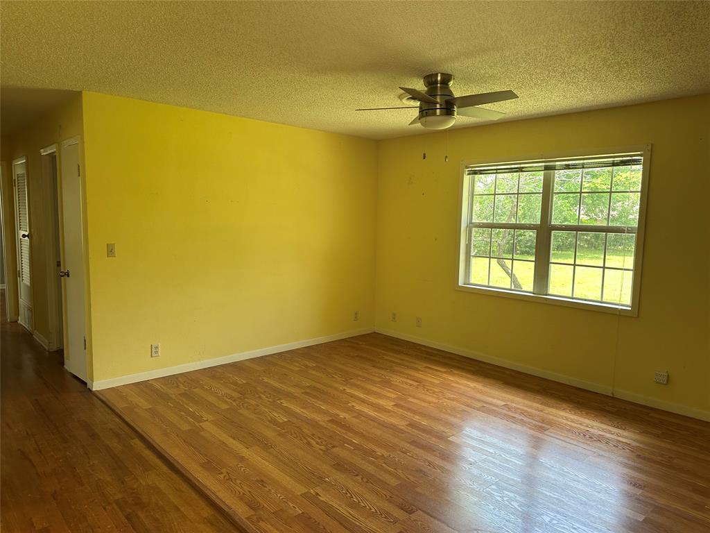 406 South Williams Street Hamilton, TX 76531 - Photo 7 of 35 a view of empty room with wooden floor and fan