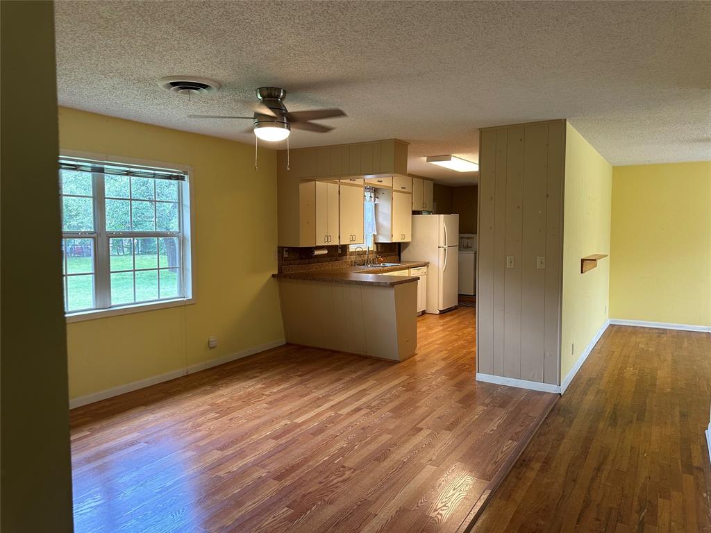 406 South Williams Street Hamilton, TX 76531 - Photo 8 of 35 a kitchen with stainless steel appliances granite countertop a refrigerator a sink dishwasher a stove and white countertops with wooden floor
