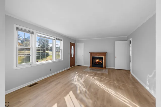 a view of an empty room with a window and fireplace
