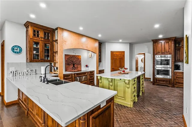a large kitchen with kitchen island a stove a sink a dining table and chairs