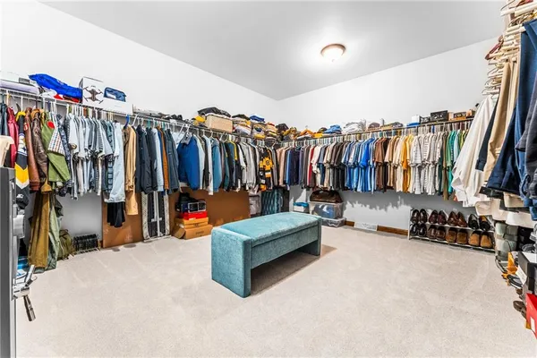 a view of walk in closet with clothes and shoes