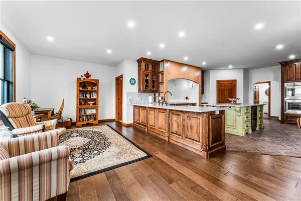 a living room with furniture large window and wooden floor