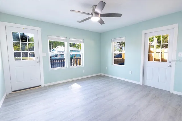 a view of an empty room with a window and wooden floor