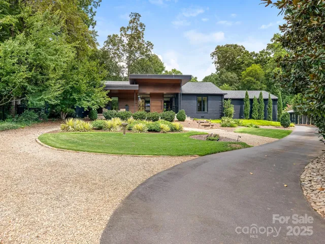 a front view of a house with a yard and trees