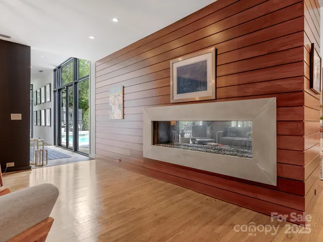 a view of a living room with wooden floor and a fireplace
