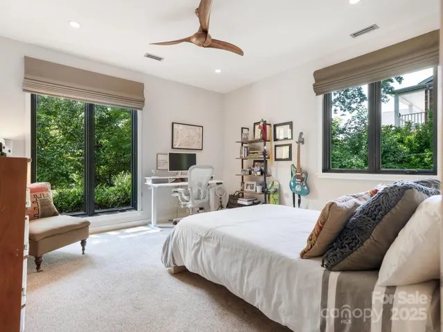 a bedroom with a bed a couch and a large window