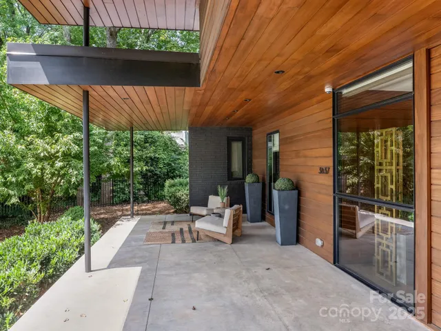 a view of a patio with table and chairs under an umbrella with a small yard