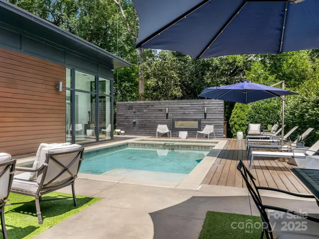 a view of a patio with chair and table under an umbrella