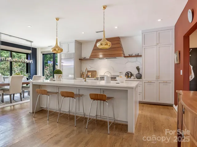 a kitchen with a sink a stove a dining table and chairs