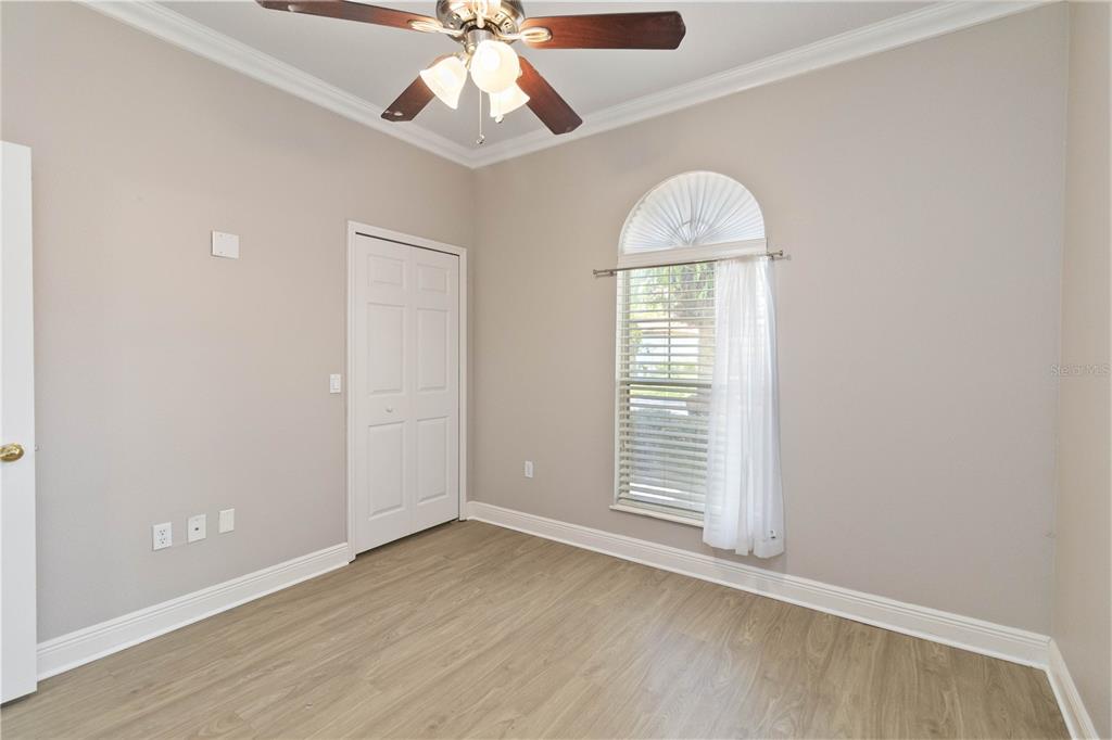 11322 Rapallo Lane Windermere, FL 34786 - Photo 23 of 39 an empty room with wooden floor chandelier fan and windows