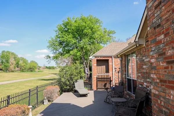 a view of a patio with lawn chairs floor to ceiling window and yard
