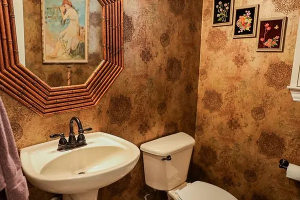 a bathroom with a sink and mirror with toilet