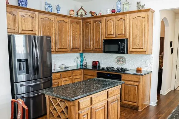 a kitchen with stainless steel appliances granite countertop a refrigerator stove and sink