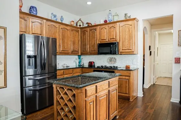 a kitchen with stainless steel appliances granite countertop sink stove top oven and refrigerator