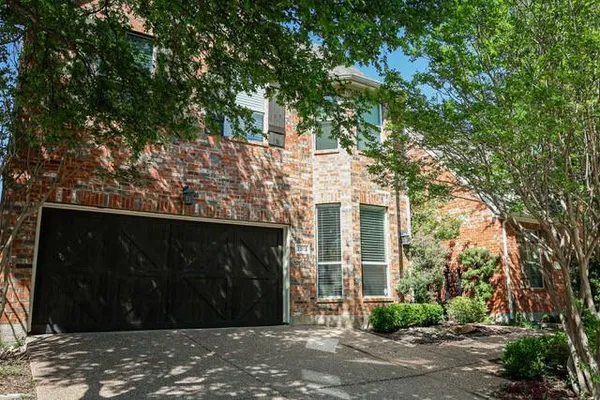a front view of a house with a tree
