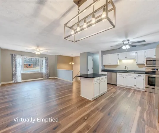 a large kitchen with cabinets wooden floor and stainless steel appliances