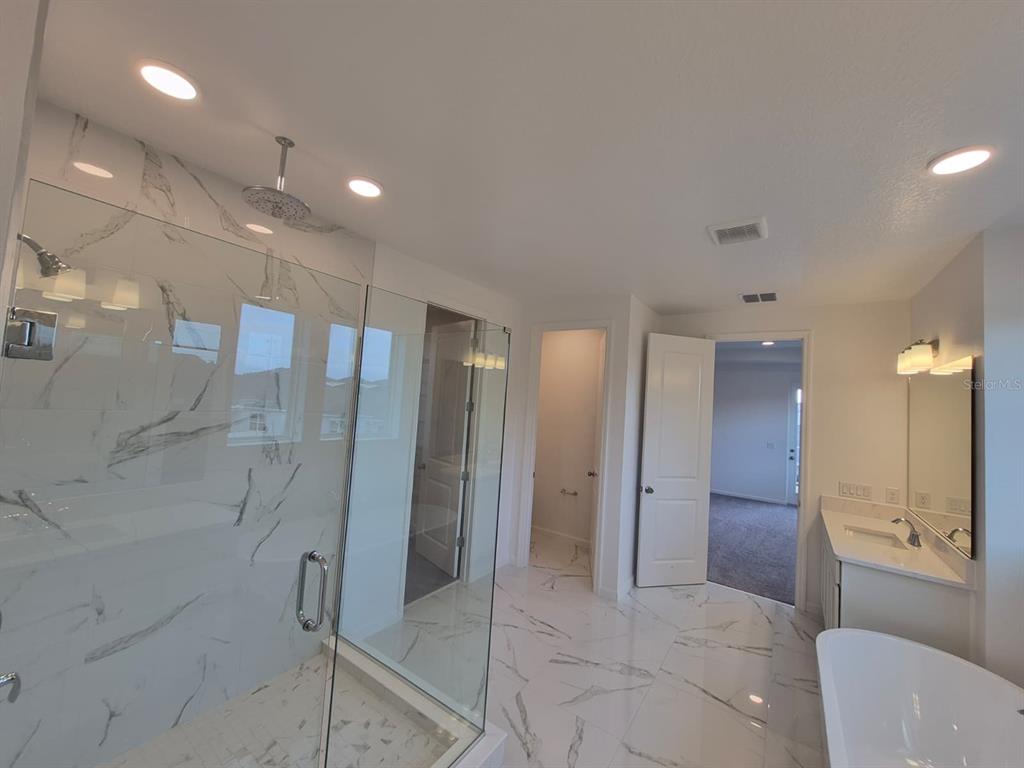 5197 Prairie Preserve Run St. Cloud, FL 34772 - Photo 17 of 39 a bathroom with a glass shower door and a sink