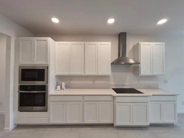 a kitchen with white cabinets and white appliances