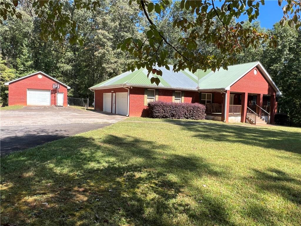 8010 Nicholson Road Cumming, GA 30028 - Photo 1 of 1 a front view of a house with a yard and trees