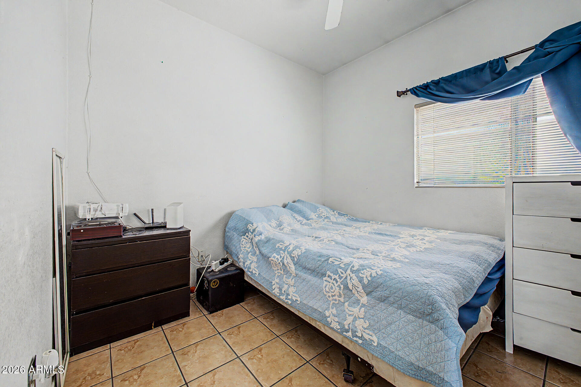 9730 West Payson Road Tolleson, AZ 85353 - Photo 20 of 57 a bed sitting in a bedroom next to a window