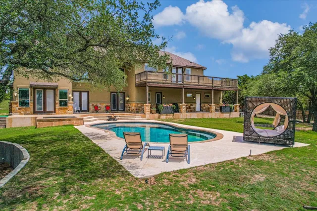 a view of a house with pool and a yard