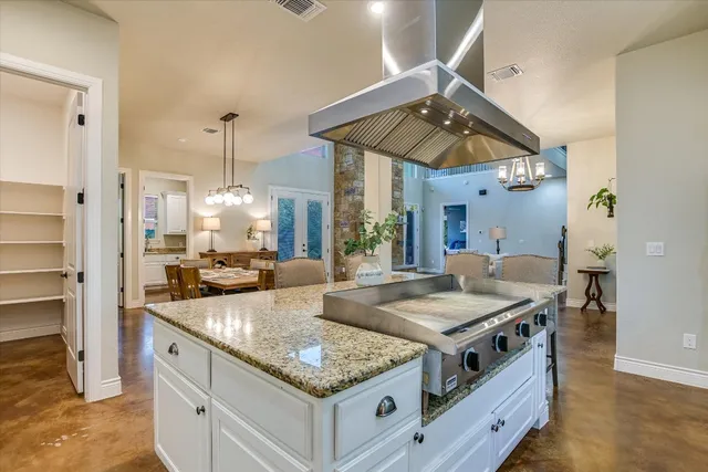 a kitchen with stainless steel appliances granite countertop a sink a stove and a refrigerator