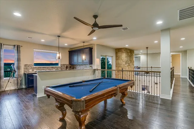 a room with pool table and windows