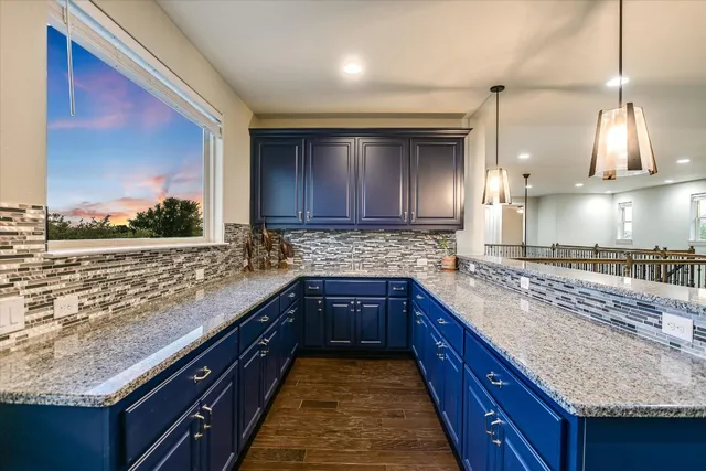 a large kitchen with kitchen island granite countertop a sink counter space and cabinets