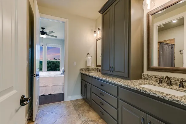 a bathroom with a granite countertop sink and a mirror