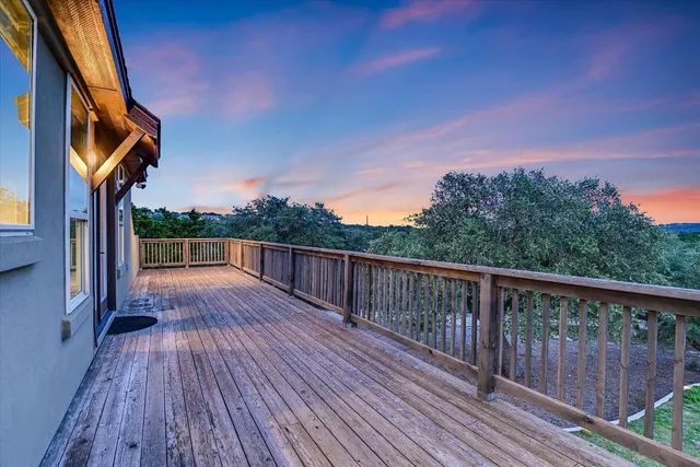 a view of balcony with wooden floor and fence