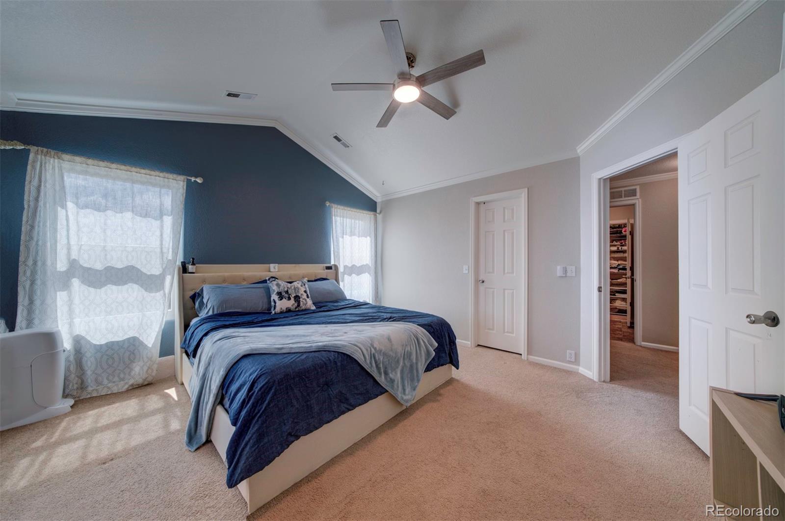 9364 Prairie Dunes Road Peyton, CO 80831 - Photo 10 of 18 a bedroom with a large bed and a ceiling fan