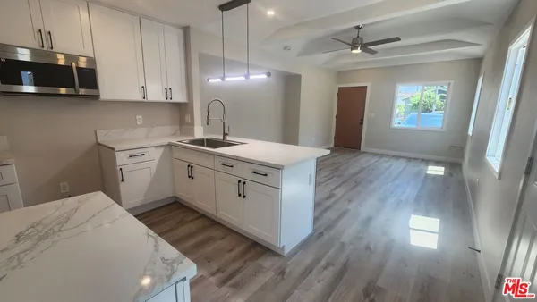 a kitchen with a sink cabinets and wooden floor