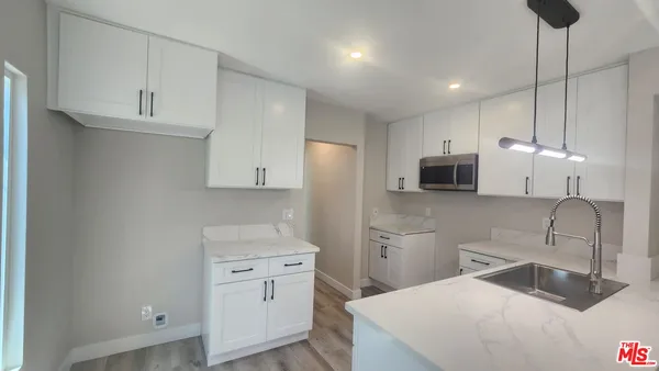 a kitchen with stainless steel appliances a sink a stove a refrigerator and cabinets
