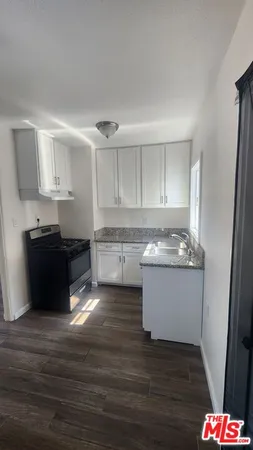 a kitchen with granite countertop a sink and cabinets