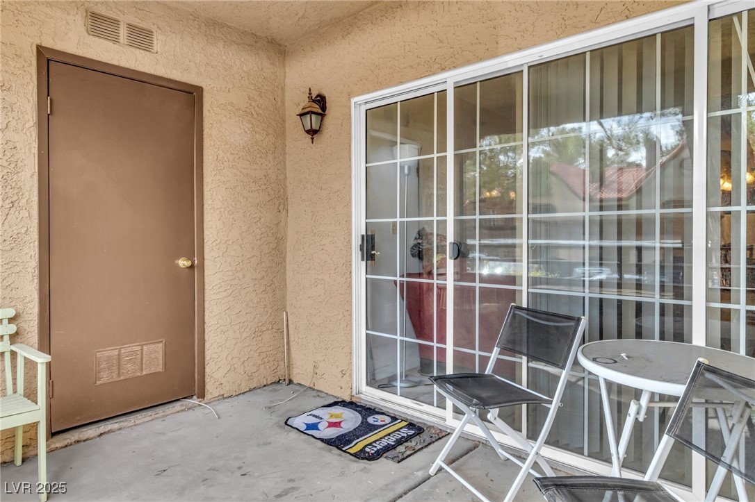 2200 South Fort Apache Road, Unit 1007 Las Vegas, NV 89117 - Photo 21 of 30 Property entrance featuring a patio area, visible vents, and stucco siding