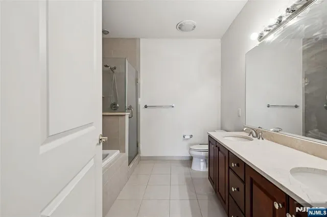 a bathroom with a double vanity sink toilet and shower