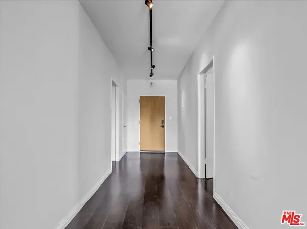 a view of a hallway with wooden floor