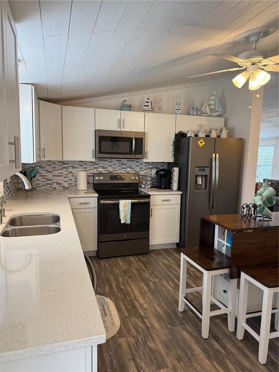 1712 Northeast King Street Steinhatchee, FL 32359 - Photo 3 of 18 a kitchen with stainless steel appliances granite countertop a refrigerator a stove a sink dishwasher and white cabinets with wooden floor