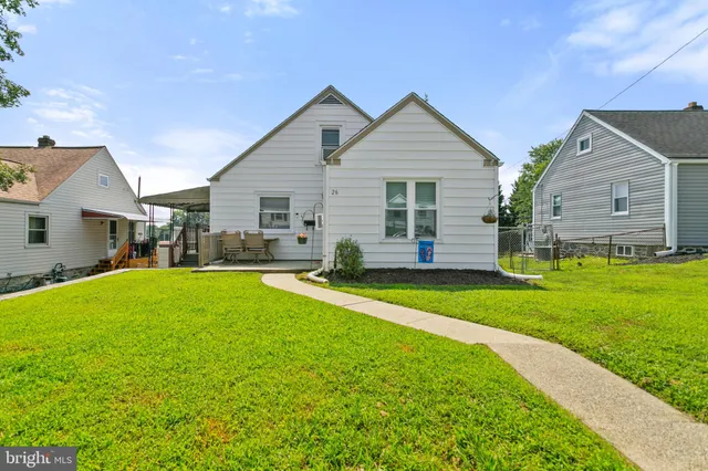 a view of a house with backyard and a tree
