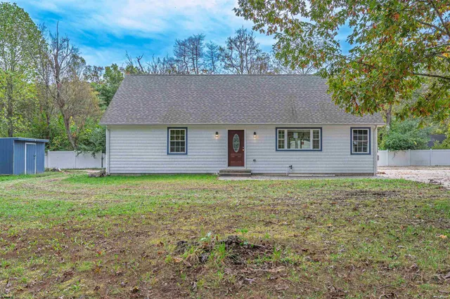 a front view of house with yard and tree in it