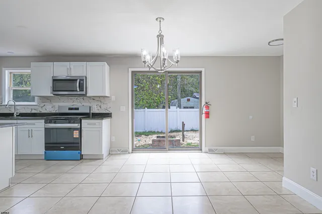 a view of a livingroom with a chandelier and glass door