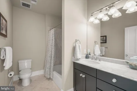 a large bedroom with a bed and glass walk in closet