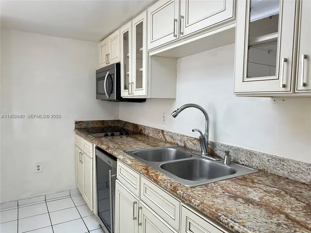 a kitchen with granite countertop a sink and a stove